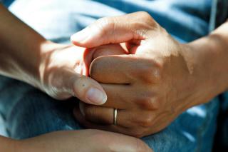 A close-up image of two sets of hands clasping together