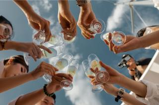 A group of people in a circle toasting with glasses of champagne
