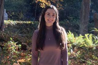 Abigail Bloom standing among trees and bushes