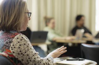 Person speaking at desk in SSW classroom