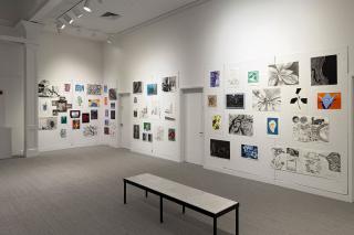 A wall in the Trustman Gallery adorned with student work