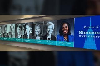 A hallway sign displaying all of the Presidents of Simmons University