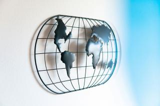A representation of the globe made into a metal wall hanging. Photo by George Bakos on Unsplash.