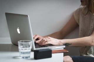 Hands typing on laptop