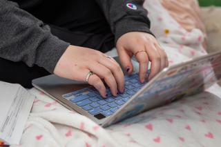 Hands typing on laptop
