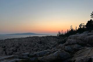 Sunset at Schoodic Point, with a view of Cadillac Mountain across the bay on Mount Desert Island