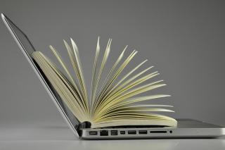 Paperback book opened on a laptop