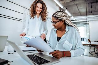 Two women working on a project at a desk
