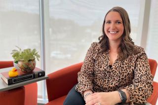 Amanda Durocher seated in a chair by a large window