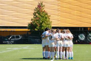 The Simmons soccer team in a huddle. Photograph by Mike Broglio.