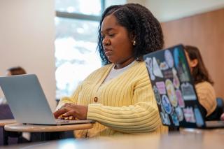 Social Work graduate student on laptop.