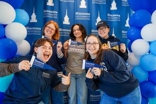 Studens posing at selfie station with Simmons swag