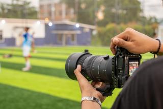 A person taking photos at a soccer game