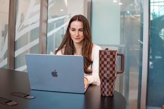 Student working at computer laptop with coffee.