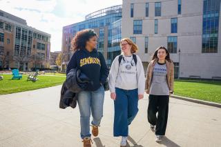 Three undergraduate students walking on the campus of Simmons University