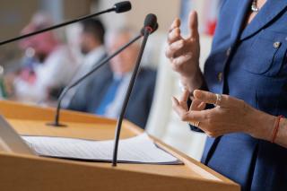 A close-up of a speaker's hands while the speaker is standing at a podium
