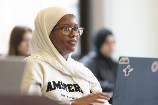Student sitting in classroom in front of laptop.