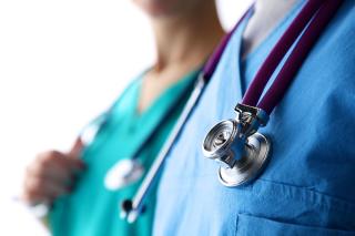 Close-up photo of two healthcare workers with stethoscopes hanging around their necks