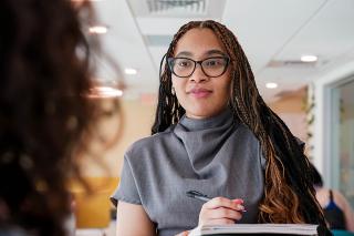 Student taking notes during conversation