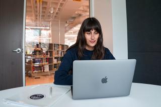 Student working in study room of library on laptop