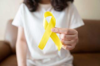 A person holding a yellow ribbon symbolizing suicide prevention