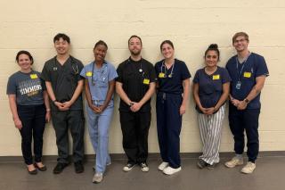 Tina Delouchry and Delmy Piano with a group of graduate nursing students who gained experience giving physical exams to middle and high school student athletes.
