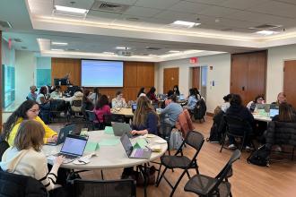 Tables of students participating in workshop to help them create a resume and LinkedIn profile