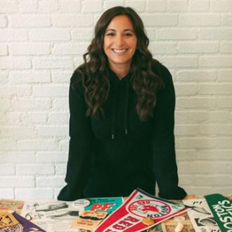 Kassia Davis standing by a table full of sports memorabilia