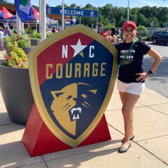 Sara Touissant standing outside a NC Courage soccer game