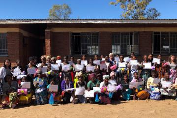 The women of Chipoka holding up their certificates, LuoPacks, and bars of soap upon completion of their women's health training!