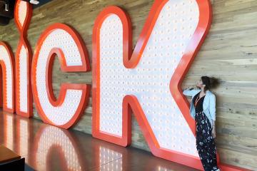 Yasmine Ebeed standed next to a giant "Nick" sign