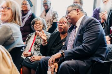 Attendees listening to speakers at the Ifill Stamp event