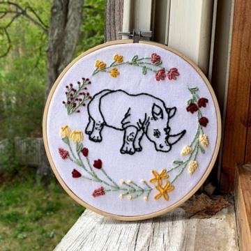 Grace Gile's embroidery of a rhinoceros surrounded by flowers