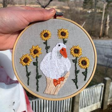 Grace Gile's embroidery of a duck surrounded by sunflowers