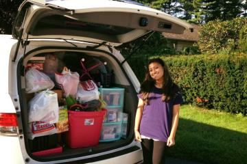 Student standing next to a car full of stuff for Simmons