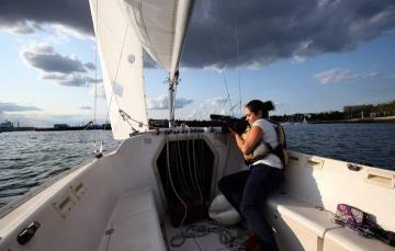 Erica Moura covering a boat story. Photo by Angela Rowlings.