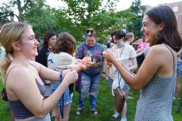 Students lighting each others' candles during the 2021 Candle Lighting Ceremony