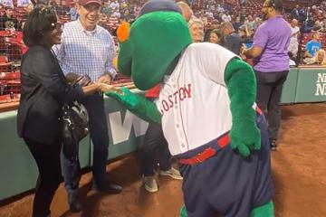President Lynn Perry Wooten meeting Wally the Green Monster at Fenway Park.