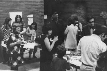 Chemistry students, faculty and staff enjoying a reception during the opening of the Park Science Center. Foreground: (l to r) Peterson's wife, Ici Hartman (Prof. of Chemistry, in dark dress), Jerry Bell (Chemistry Chair, w glasses & trademark bowtie)