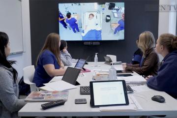 A group of students observing a simulation lab training on a monitor