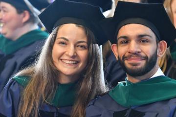 2 graduate students enjoying the 2025 Commencement ceremony