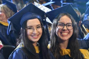 2 undergraduate students enjoying 2025 Commencement