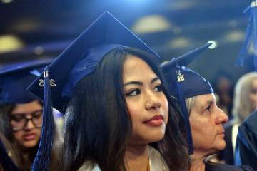 A member of the Class of 2025 listening to the speakers at Commencement
