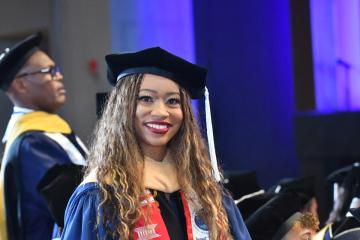 A graduate student in cap and gown