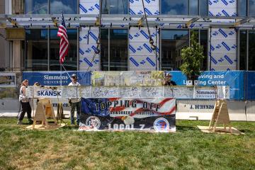 The fully signed beam is prepared to be raised in place at the LLC Topping Off Ceremony