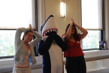 Orientation 2025 - Students making shark fin poses with Stormy