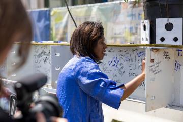 Simmons President Lynn Perry Wooten signs the final beam at the LLC Topping Off Ceremony