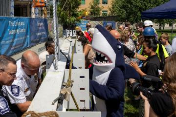 Stormy the mascot signing the beam at the LLC Topping Off Ceremony