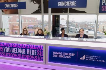 Four students at the Concierge desk during the Simmons Leadership Conference 2025