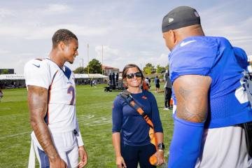 Alexia Malone Oliver on the field talking with NFL players